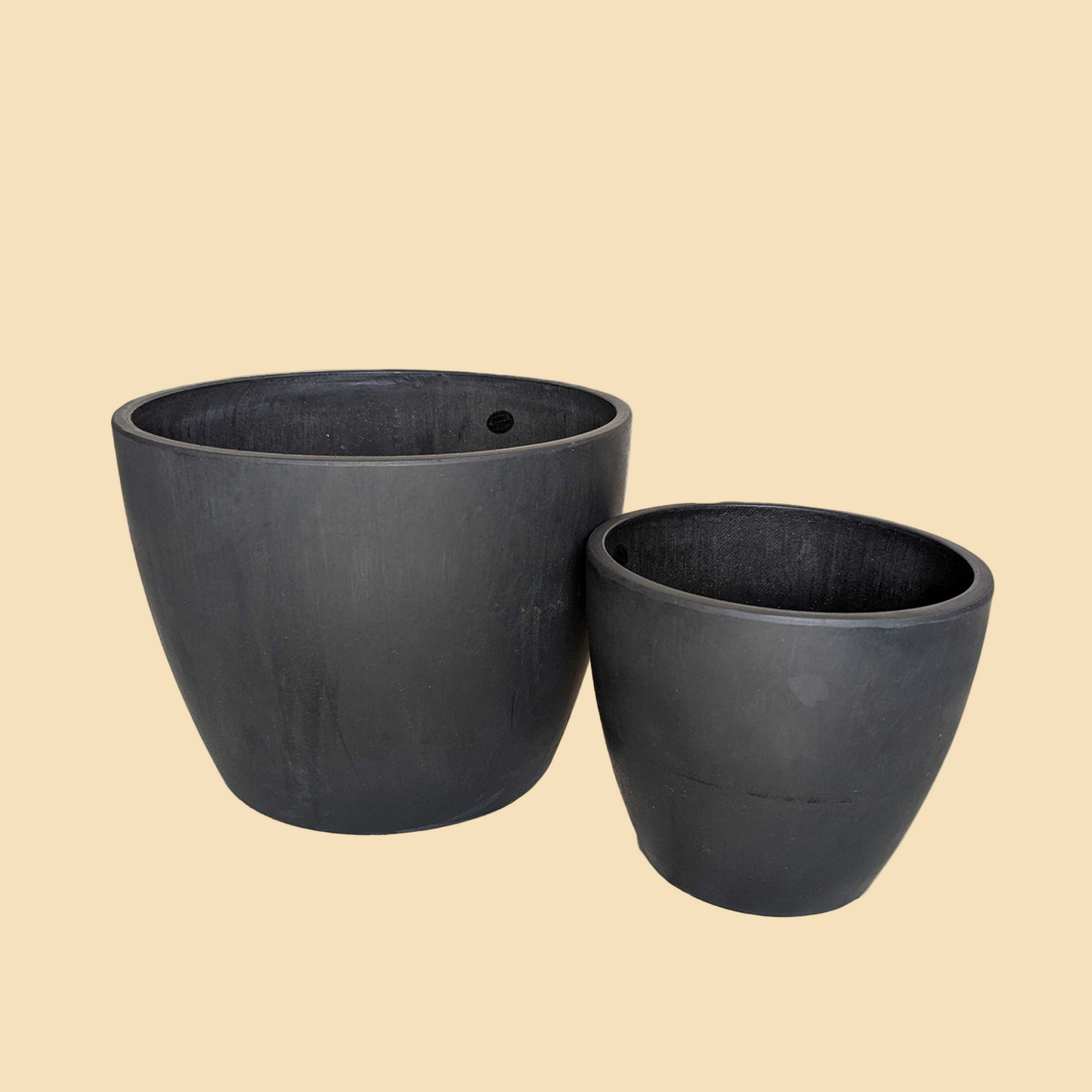 Two black plant pots on a white background